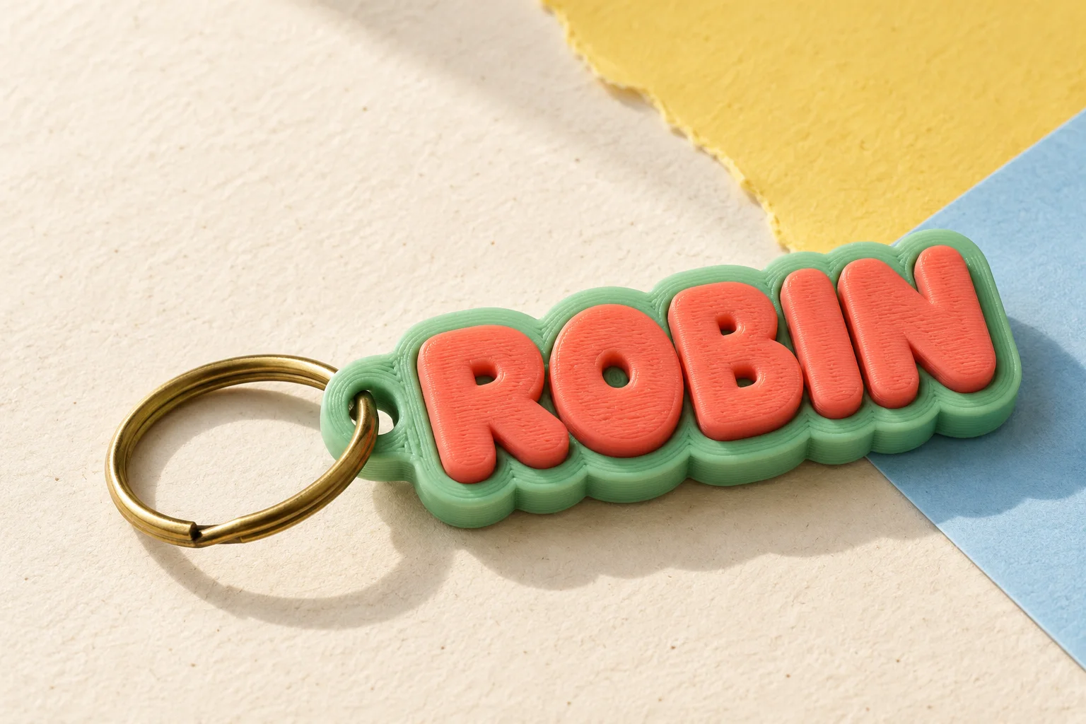 Coral and mint 3D-printed keyring spelling Robin